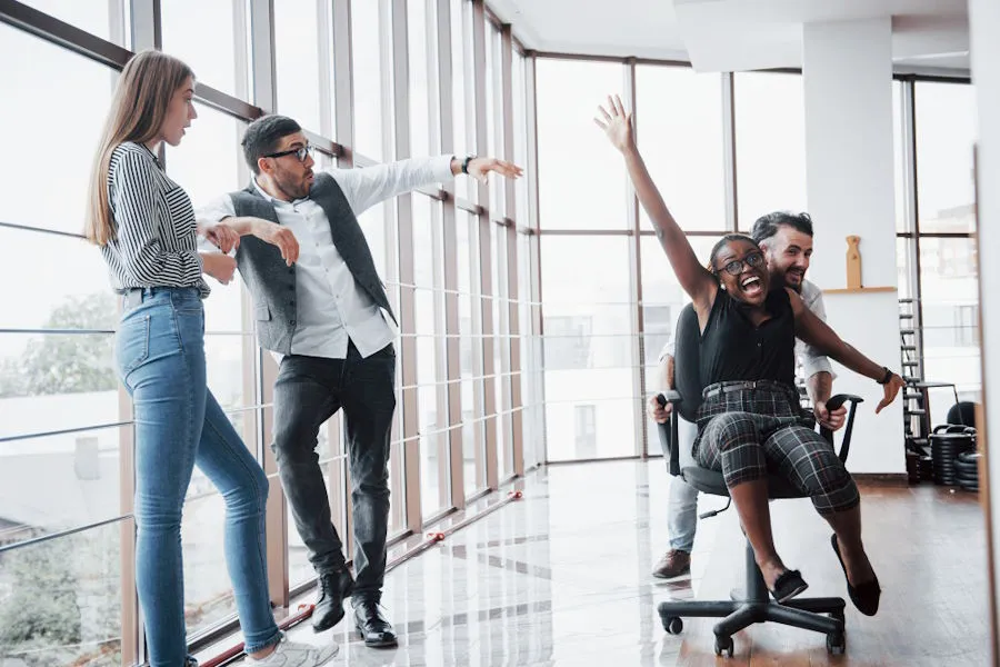 Des employés s'amusent avec une chaise roulante de bureau